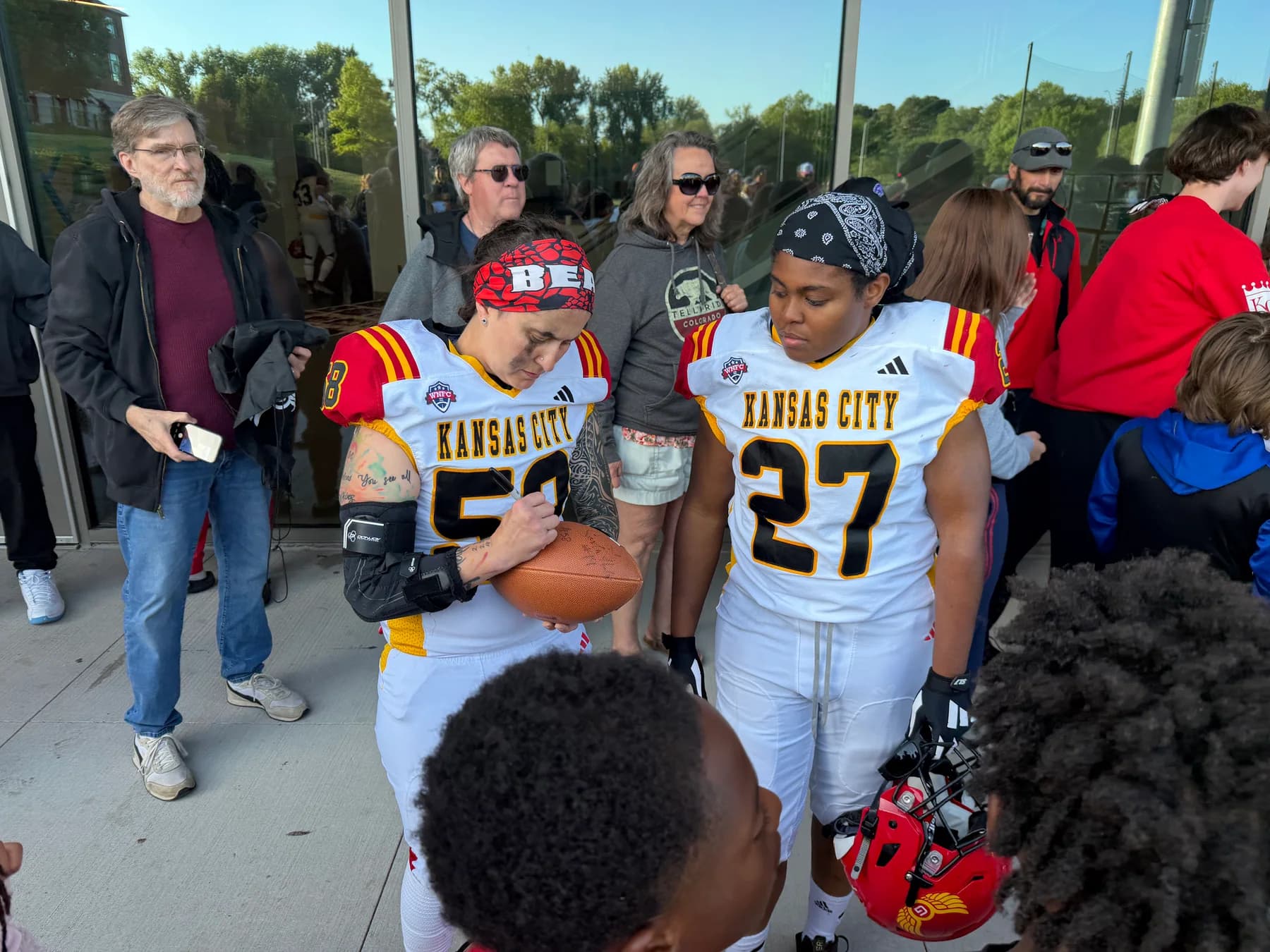 Football players talking with children and families
