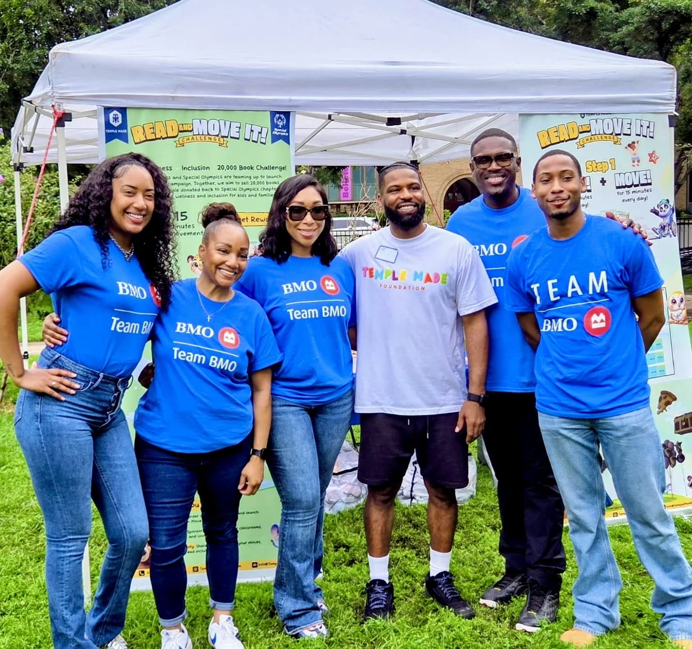 BMO team members and a Temple Made Foundation coach standing together in front of Read and Move It program banners in Chicago