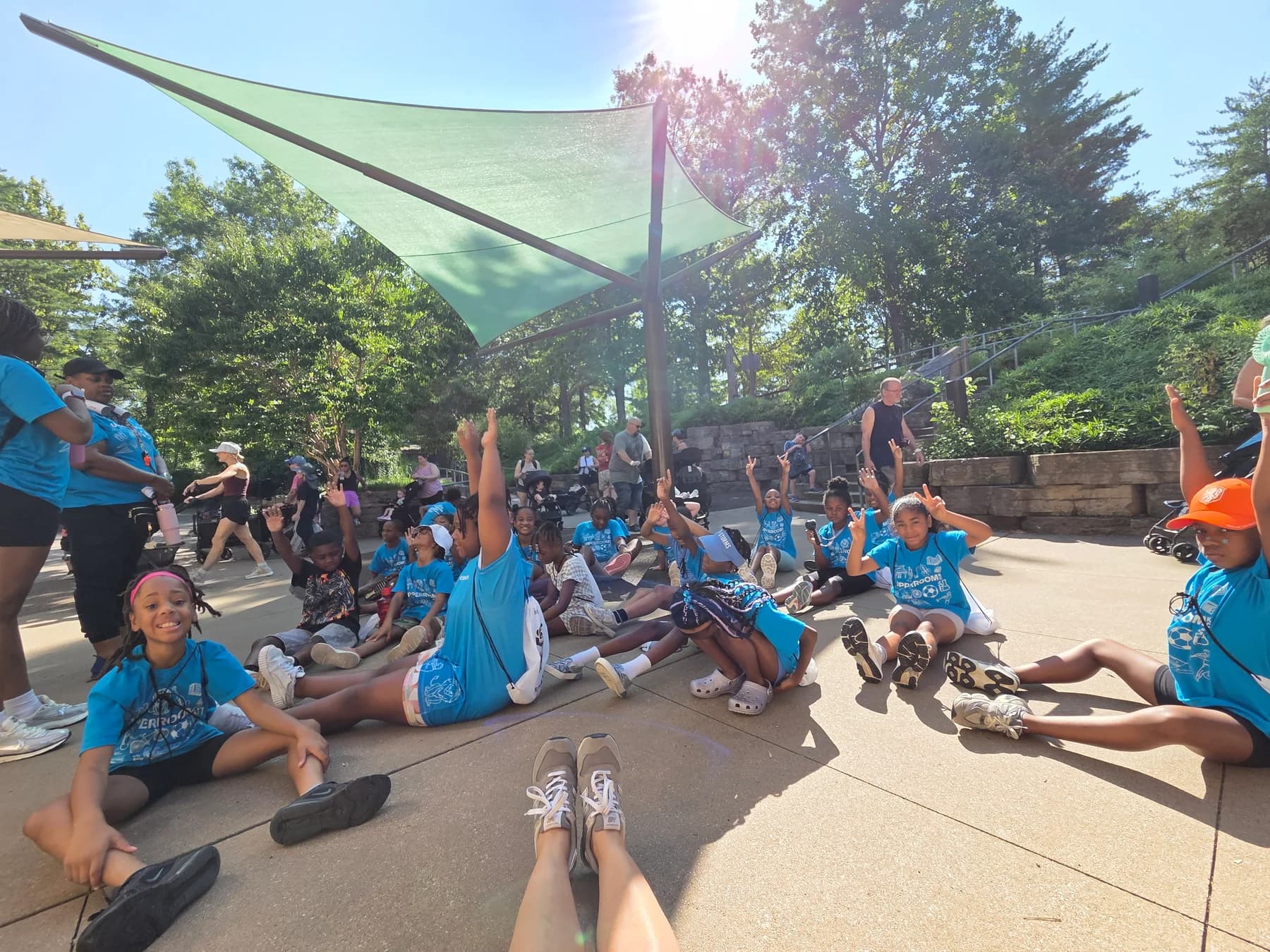 A large group of children participating in a movement activity at the zoo